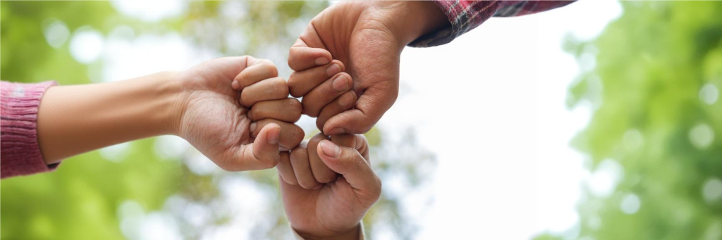 Mãos de participantes de ONG unidas em forma de comemoração